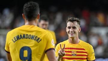 Barcelona's Spanish midfielder #17 Marc Casado (R) celebrates with Barcelona's Polish forward #09 Robert Lewandowski at the end of the Spanish league football match between Valencia CF and Barcelona at the Mestalla stadium in Valencia on August 17, 2024. (Photo by JOSE JORDAN / AFP)