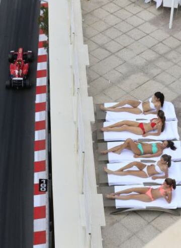 Cinco chicas tomando el sol mientras el piloto de Ferrari, Felipe Massa conduce durante la tercera sesión de entrenamientos en el Circuito de Mónaco.