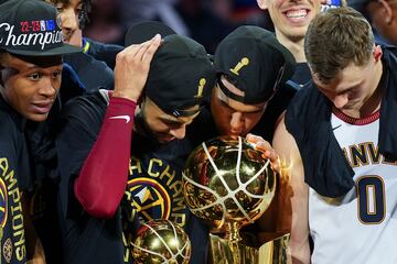 Michael Porter Jr. y Jamal Murray besan el ansiado trofeo de campeones de la NBA.