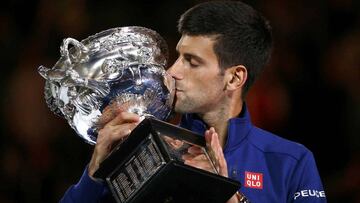 Novak Djokovic besa el trofeo de campe&oacute;n del Abierto de Australia 2016.