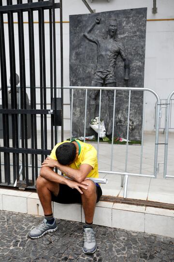 Un aficionado llora delante de una estatua de Pelé en el estadio Vila Belmiro en la ciudad de Santos, Brasil.