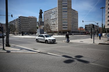 Una persona camina por un cruce peatonal mientras pasa un automóvil durante un apagón en Lisboa, Portugal.