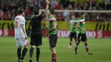 Mateu muestra la tarjeta amarilla a De Marcos en Sevilla.