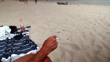 A beachgoer smokes a cigarette on the beach at La Baule on the Atlantic coast, as a nationwide ban on smoking is due to come into effect on July 1, at beaches, parks and outside schools to protect children, France, June 25, 2025. REUTERS/Stephane Mahe