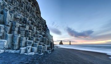 Las columnas de basalto, la arena negra y las formaciones rocosas que emergen del agua son las protagonistas en esta playa islandesa.