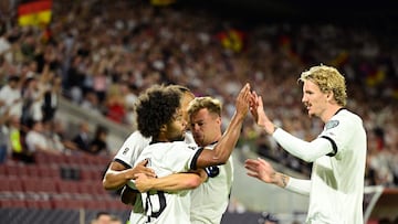 Germany's midfielder #20 Serge Gnabry (L) celebrates with Northern Ireland's forward #11 Jamie Reid (R) and team playerser scoring the opening 1-0 goal during the 2026 World Cup qualifiers Europe zone group A football match between Germany and Northern Ireland on September 7, 2025 in Cologne, western Germany. (Photo by INA FASSBENDER / AFP)
