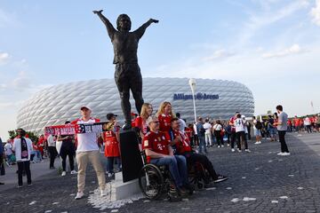 Aficionados del Bayern de Munich posan junto a una estatua de Gerd "Torpedo" Müller en los aledaños del Allianz Arena.  Leyenda goleadora del Bayern en los años 60 y 70.