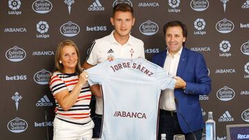 Jorge Saenz posa con la camiseta del Celta durante su presentación acompañado por María José Táboas y Felipe Miñambres.