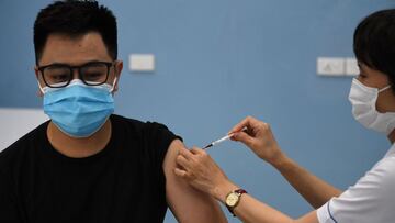 A health worker administers a dose of the AstraZeneca vaccine for the Covid-19 coronavirus at the Bach Mai Hospital in Hanoi on May 17, 2021. (Photo by Nhac NGUYEN / AFP)