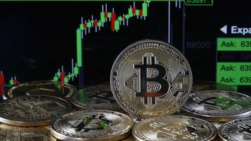 PARÍS, FRANCIA - 14 DE ABRIL: En esta ilustración fotográfica, una representación visual de la criptomoneda digital, Bitcoin se exhibe frente al gráfico del curso de Bitcoin el 14 de abril de 2021 en París, Francia.