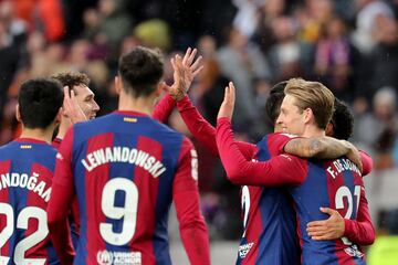 Barcelona's Dutch midfielder #21 Frenkie de Jong (R) celebrates with teammates scoring his team's third goal with teammates during the Spanish league football match between FC Barcelona and Getafe CF at the Estadi Olimpic Lluis Companys in Barcelona on February 24, 2024. (Photo by LLUIS GENE / AFP)