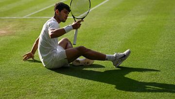 Carlos Alcaraz cae durante su partido contra Jannik Sinner en Wimbledon.
