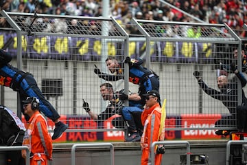 Operarios de Red Bull celebran subidos a las verjas la victoria del piloto neerlandés de Red Bull.