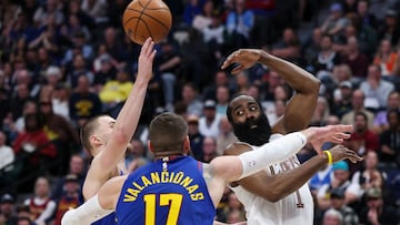 James Harden #1 of the Cleveland Cavaliers passes the ball between Nikola Jokic #15 and Jonas Valanciunas #17 of the Denver Nuggets during the fourth quarter of the game at Ball Arena on February 9, 2026 in Denver, Colorado.