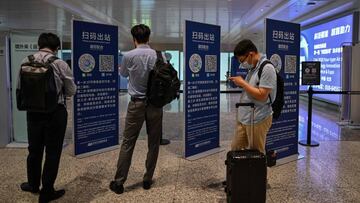 This photo taken on August 3, 2020 shows passengers checking their health codes on their phones upon arrival at Tianhe Airport in Wuhan in Chinax92s central Hubei province. - The city's convalescence since a 76-day quarantine was lifted in April has brought life and gridlocked traffic back onto its streets, even as residents struggle to find their feet again. Long lines of customers now stretch outside breakfast stands, a far cry from the terrified crowds who queued at city hospitals in the first weeks after a city-wide lockdown was imposed in late January to curb the spread of the COVID-19 coronavirus. (Photo by Hector RETAMAL / AFP)