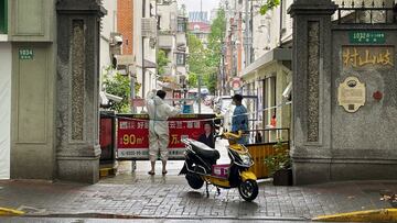 FILE PHOTO: A courier in a protective suit makes deliveries to a residential compound amid the coronavirus disease (COVID-19) outbreak in Shanghai, China, April 23, 2022. REUTERS/Brenda Goh/File Photo