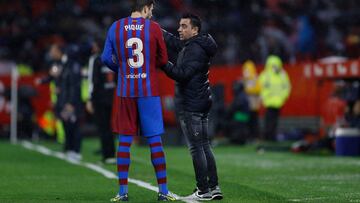 Barcelona manager Xavi gives Gerard Piqué instructions during the match against Sevilla.