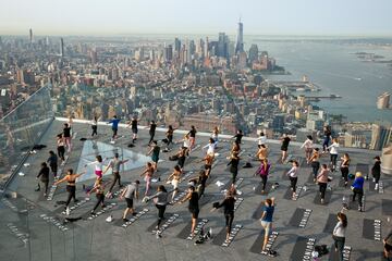 Un grupo de personas hace yoga en la azotea de un edificio de Manhattan (Nueva York). Como ocurre con muchos tipos de ejercicios al aire libre, esta práctica cogió gran demanda durante la pandemia del coronavirus, y no se ha pasado de moda, sino más bien al contrario: hay semanas de lista de espera para asistir a las clases.