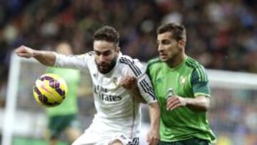 El defensa del Real Madrid Daniel Carvajal (i) lucha un balón con el defensa del Celta de Vigo Jonny Castro (d), durante el partido correspondiente a la decimocuarta jornada de Liga que disputan en el estadio Santiago Bernabéu de Madrid.