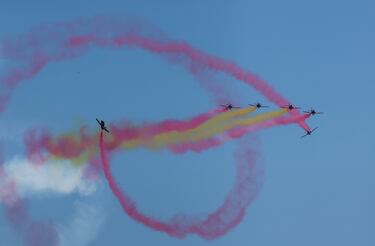 Miembros del grupo acrobático del Ejército del Aire español 'Patrulla Águila' sobrevuelan la pista antes de la carrera.