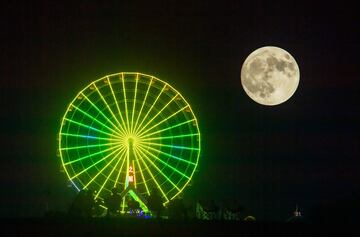 La luna llena aparece en el cielo nocturno sobre una noria en un parque durante las vacaciones del Festival del Medio Otoño el 17 de septiembre de 2024 en Guang'an, provincia de Sichuan, China.