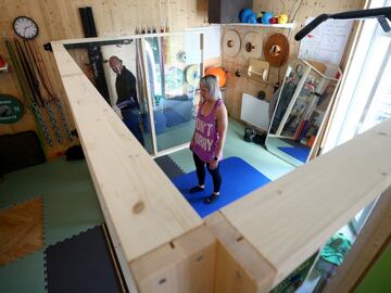 El fisioterapeuta Roman Pallesits observa la sesión de entrenamiento de la kickboxer austriaca Nicole Trimmel, quien realiza ejercicios de gimnasia en el interior de una caja de plexiglas. Se trata de un espacio diseñado y construido para que Trimmel pueda seguir con su preparación durante la expansión del coronavirus por Austria.