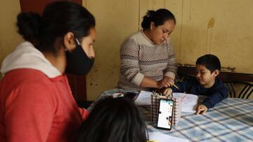 Ángel y Cinthia Palomino participan en una clase de tele-escuela en linea desde su vivienda en el asentamiento humano la Nueva Rinconada, en Pamplona, un barrio del populoso distrito limeño de San Juan de Miraflores (Perú). EFE/ Paolo Aguilar