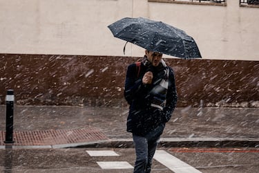 Un hombre camina bajo la nieve en Madrid.