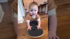 Olive Sheckler, con 10 meses, sobre una tabla de skate.