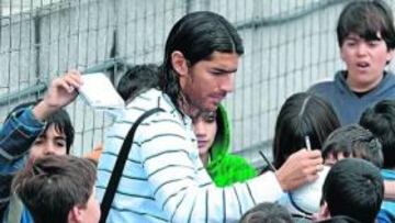 <b>ÍDOLO. </b>Abreu firma un balón rodeado de niños e hinchas de la Real tras el entrenamiento de ayer.