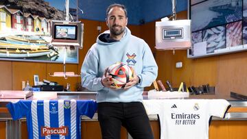 Pesca, jugador de la Arandina, posa con el balón de la Copa del Rey y las camisetas de su equipo y el Real Madrid en la pescadería familiar.