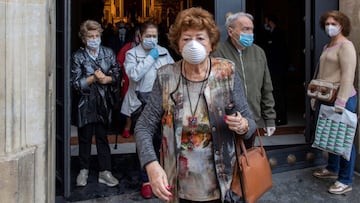Varios fieles con mascarillas salen del interior de la Basílica de Jesús del Gran Poder.