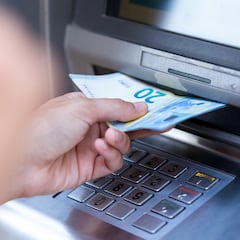 Cierre a la niña con un reembolso en una máquina de efectivo