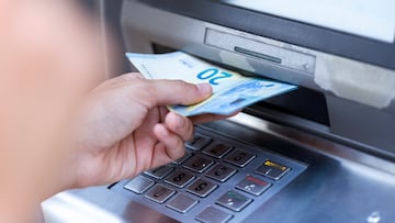 Close up of businesswoman withdraw money on a cash machine