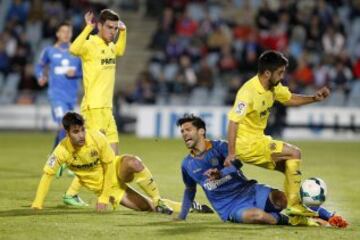 El centrocampista del Getafe Ángel Lafita (c) pelea un balón con varios rivales del Villarreal.