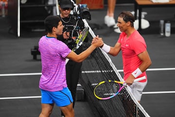 Carlos Alcaraz y Rafa Nadal se saludan tras finalizar el partido de exhibici¨®n.