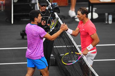 Carlos Alcaraz y Rafa Nadal se saludan tras finalizar el partido de exhibición.