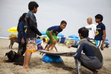 Niños durante una lección de surf en una playa cerca de Alto Perú barrio de chabolas de Lima.  Desde 2008, la ONG Alto Perú busca ofrecer a los niños de un barrio pobre de pescadores conocido como Alto Perú, la oportunidad de aprender y practicar deportes alternativos como el surf y el Muay Thai de forma gratuita.