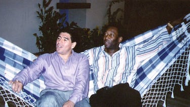 Las leyendas del fútbol Diego Maradona (izq.) Y Pele descansan en una hamaca durante una recepción en Río de Janeiro, el 14 de mayo de 1995.