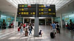 FILE PHOTO: People walk under a sign at Barcelona-El Prat airport, Spain August 4, 2017. REUTERS/Albert Gea/File Photo