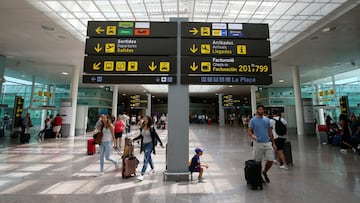 FILE PHOTO: People walk under a sign at Barcelona-El Prat airport, Spain August 4, 2017. REUTERS/Albert Gea/File Photo