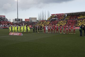 Los jugadores del Barcelona y del Girona saludan desde el centro del campo. 