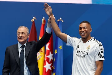 Florentino alza el brazo de Mbappé, durante la presentación.