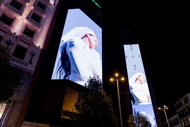 Decenas de personas observan la portada del nuevo álbum de Rosalía, 'Lux', en la plaza de Callao.