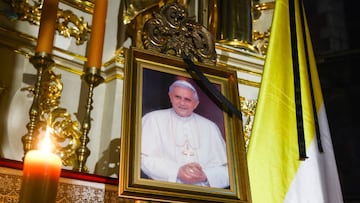 The Corpus Christi Basilica commemorates the late Pope Emeritus Benedict XVI displaying his portrait picture with a black ribbon next to the papal flag, on January 03, 2023 in Krakow, Poland. Benedict XVI, whose secular name was Joseph Aloisius Ratzinger, died on December 31 at the age of 95. Benedict's funeral will be held on January 5th  in St. Peter's Square in Vatican City.  (Photo by Beata Zawrzel/NurPhoto via Getty Images)