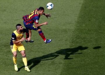 El defensa brasileño del FC Barcelona, Adriano Correia (d), salta ante el centrocampista turco del Atlético de Madrid, Arda Turan.