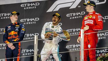 Abu Dhabi (United Arab Emirates), 01/12/2019.- Winner British Formula One driver Lewis Hamilton (C) of Mercedes, second placed Dutch driver Max Verstappen (L) of Red Bull and third placed Monaco's Charles Leclerc of Ferrari celebrate with champagne on the