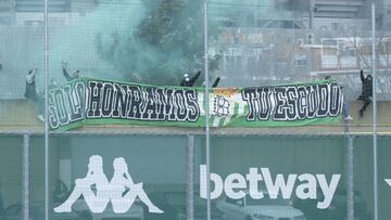 La pancarta y las bengalas verdiblancas con las que ultras béticos intentaron ayer animar a sus jugadores en la Ciudad Deportiva.