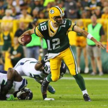 Aaron Rodgers QB de Green Bay Packers zafándose de la presión rival.