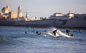 Surfistas cogiendo ola en la playa de Santa María del Mar, Cádiz, tras las medidas de desescalada del Gobierno con altas temperaturas durante el fin de semana. 